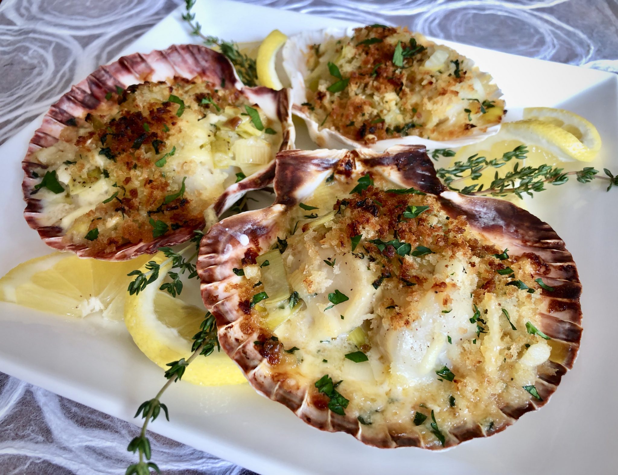 SCALLOPS AU GRATIN BATHED IN GARLIC LEEK CREAM WITH GARLIC PANKO CRUST