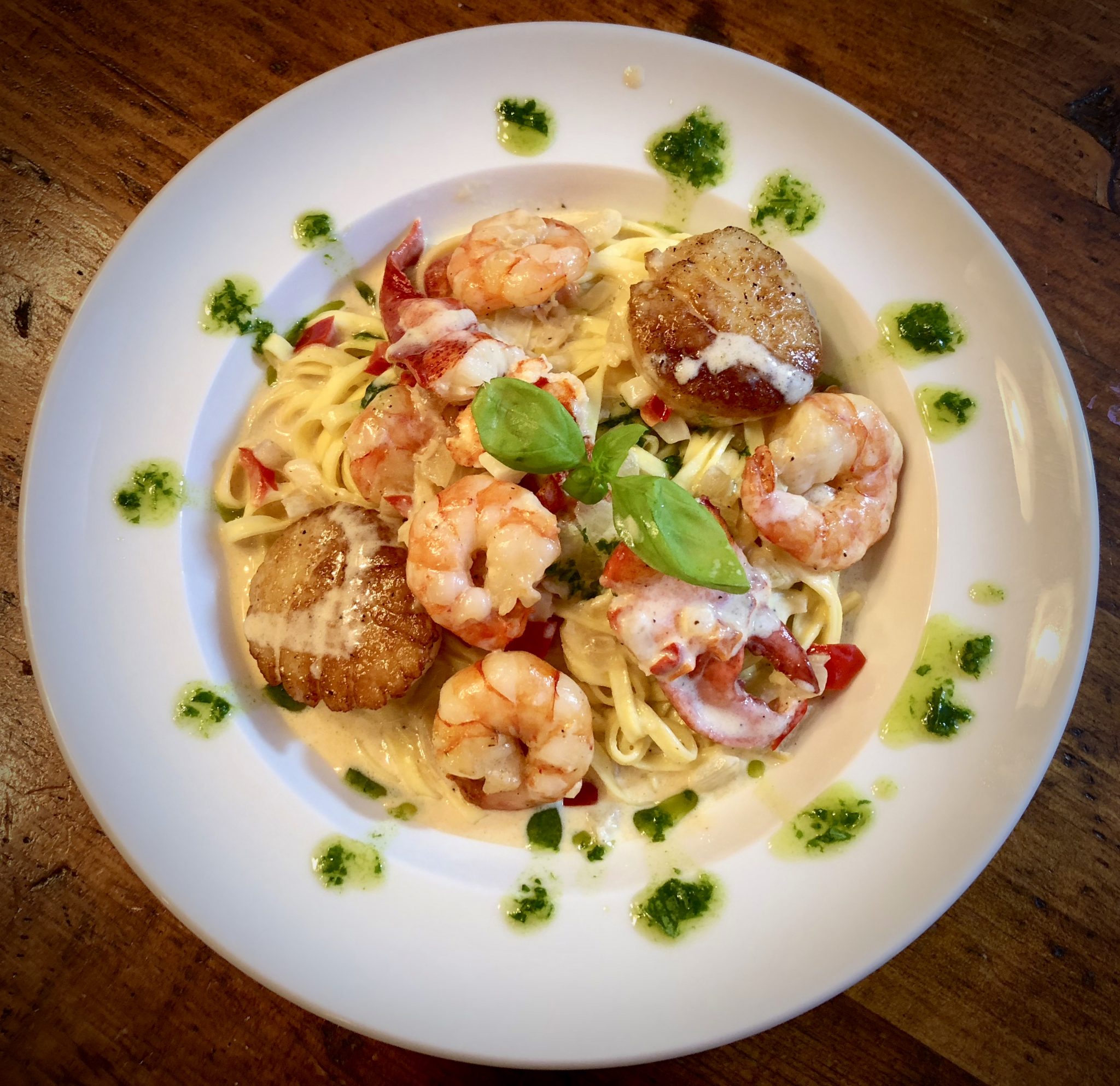 LOBSTER, SHRIMP, AND SCALLOPS OVER FRESH LINGUINI BATHED IN DECADENT