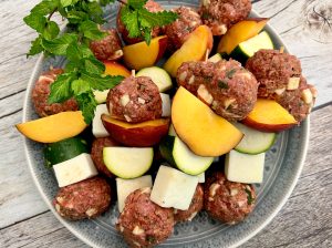 Glazed Lamb Meatball, Paneer, Peach, And Zucchini Skewers Over Couscous