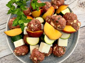 GLAZED LAMB MEATBALL, PANEER, PEACH, AND ZUCCHINI SKEWERS OVER COUSCOUS
