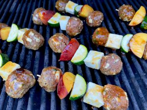 GLAZED LAMB MEATBALL, PANEER, PEACH, AND ZUCCHINI SKEWERS OVER COUSCOUS